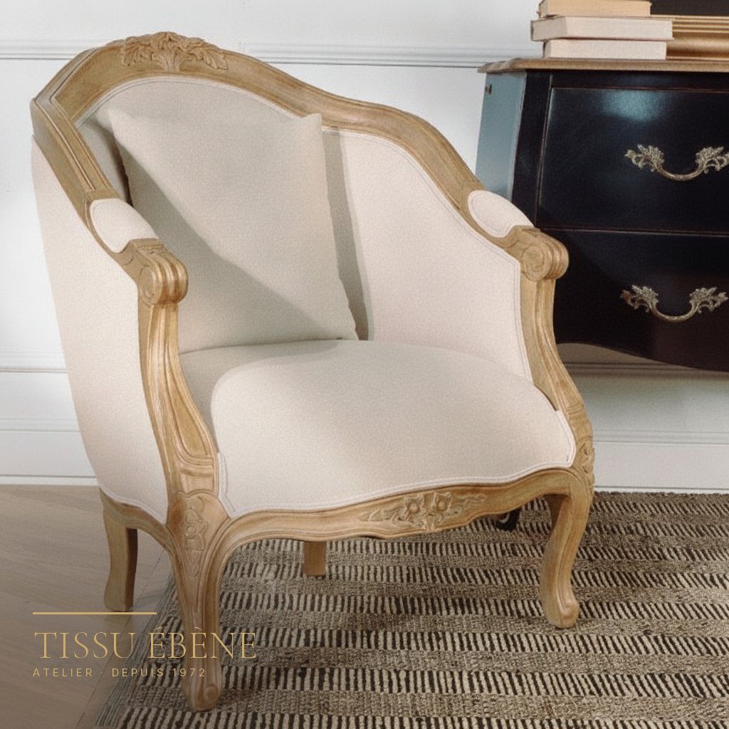Bergère de style Louis XV en bois naturel sculpté, garnie d’un tissu ivoire uni
